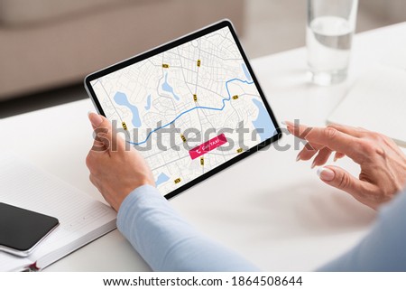 Online Taxi Service. Unrecognizable businesswoman Checking Cab Geolocation On Virtual Map On Digital Tablet, Sitting At Desk In Office, Booking Transfer Car, Enjoying Modern Transportation, Royalty-Free Stock Photo #1864508644
