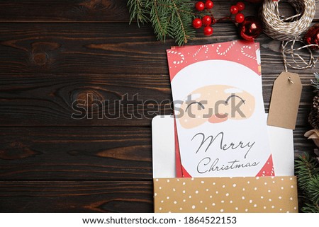 Flat lay composition with Christmas cards on wooden background, space for text