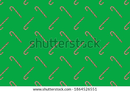 Traditional Christmas candy cane on green background