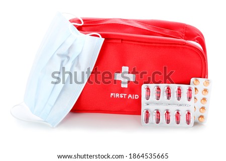 First aid kit with medicine mask and pills isolated on white background