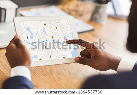 Unrecognizable Black Businessman Using Taxi Services App On Digital Tablet In Office, Looking At Virtual Map With GPS Trackers, Checking Nearest Cab, Creative Collage For Transportration Concept Royalty-Free Stock Photo #1864537756