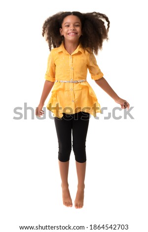 Cute multiracial small girl jumping and laughing - Isolated on a white background