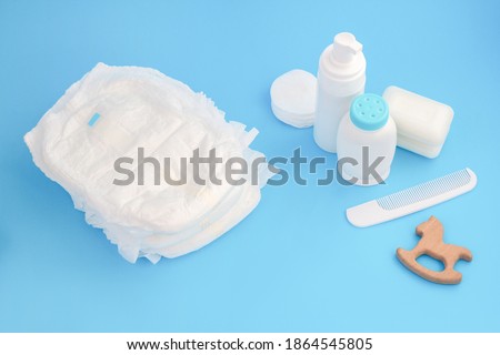 Baby hygiene. Daily care. Cleaning and washing accessories. Disposable nappy, cream and soap. Powder, teether and comb. Royalty-Free Stock Photo #1864545805