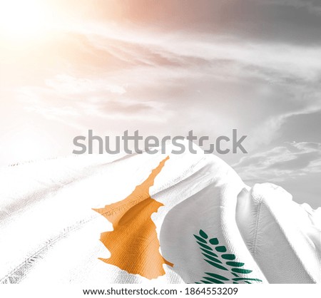 Cyprus national flag cloth fabric waving on beautiful sky background.