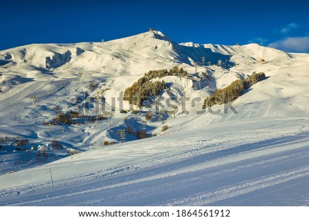 Stunning winter landscape with popular ski resort at morning. Empty ski slopes and spectacular scenery, La Toussuire, France, Europe Royalty-Free Stock Photo #1864561912