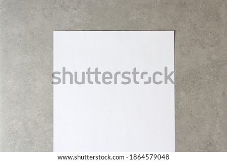 Template of white paper on light grey concrete background. Concept of new idea, business plan and strategy, development and implementation of content. Stock photo with empty space for text.