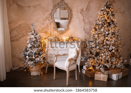 Christmas gifts are under the tree. A snow-covered tree and a chair near the fireplace. New year's interior decor.