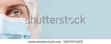 Coronavirus. Covid 19. Protection against infectious disease, coronavirus. Female doctor in white hazmat protective suit and a medical mask with a copy space. Horizontal panoramic banner. Epidemic of Royalty-Free Stock Photo #1864591603