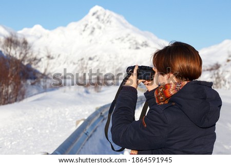girl travels around lofoten islands and takes pictures on camera. Norway
