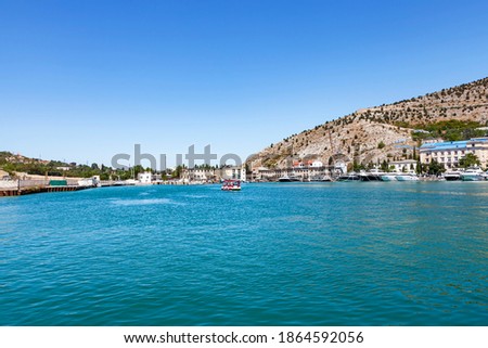 Water transport. Beautiful yachts, ships at sea against the backdrop of a mountainous coastal strip, in summer in clear sunny weather.