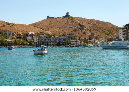 Water transport. Beautiful yachts, ships at sea against the backdrop of a mountainous coastal strip, in summer in clear sunny weather.