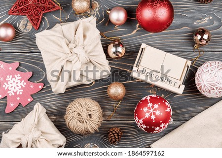 Christmas composition. Gifts wrapped in cloth, Christmas balls and decorations. Calendar without date.