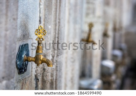 Water tap for washing hands and feet before the prayer in ablution faucets in the Suleymaniye Mosque, Istanbul, Turkey. Royalty-Free Stock Photo #1864599490
