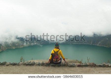girl travel photographer in spectacular landscape lagoon inside volcano with mist quilotoa ecuador latin america