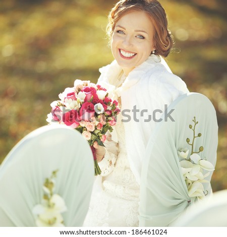 Wedding sunny picture of happy bride with bouquet.
