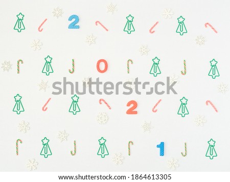 Multi-colored soft English numbers 2021 with Christmas tree formed clips, Xmas canes, snowflakes on white background. Back to school, Christmas in office concept. Xmas greeting card. Flat lay style.