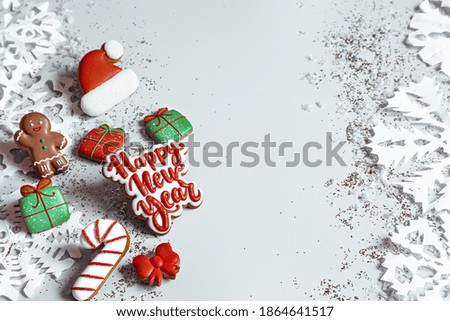 Winter background with decorated with glaze gingerbread, snowflakes and confetti top view. Happy new year and christmas concept.