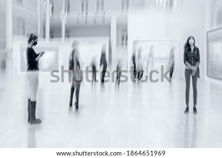 abstract image of people in the lobby of a modern art center with a blurred background