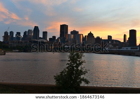 Montreal Downtown skyline at the time between sunset and twilight. Reflections of sun rays on Saint Laurent river. Summer, Spring, outdoors, hope, inspiration, thankfulness, love, happiness concepts.