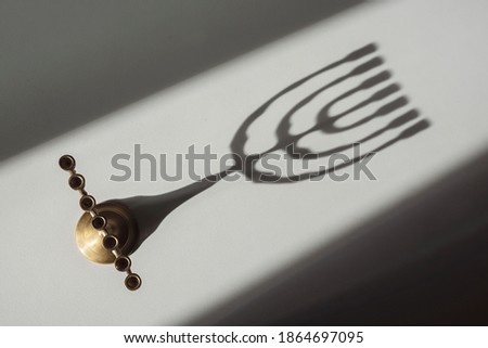 View from above of a Jewish candlestick and its shadow