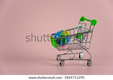 small empty shopping cart with globe on pink background Royalty-Free Stock Photo #1864715290