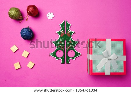 Flatlay picture of Christmas tree with gift box, Christmas ball, word tiles and snowflake. Christmas gift concept.