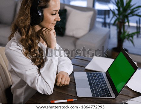 Young business woman with her laptop - green screen display - home shooting