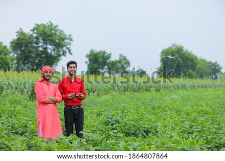 Indian farmer and agronomist using drone at agriculture field