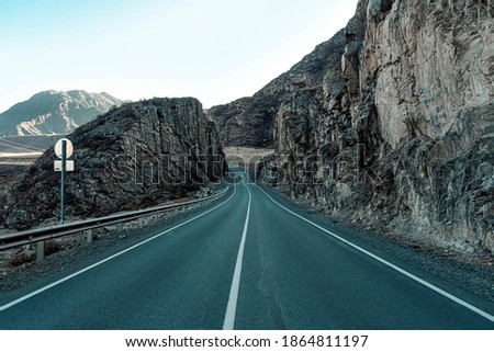 Road in mountains. The paved road passes through the rocks. Beautiful scenery. Chuysky tract in the Altai Republic. Royalty-Free Stock Photo #1864811197