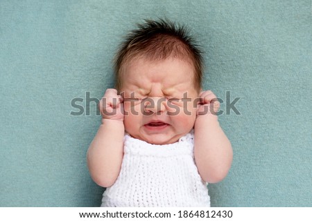 portrait of crying newborn baby. emotions of discontent. colic. Selective focus Royalty-Free Stock Photo #1864812430