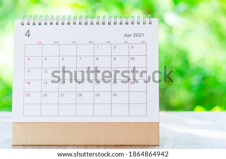 Calendar desk 2021 April month for organizer to plan and reminder on wooden table on nature background.