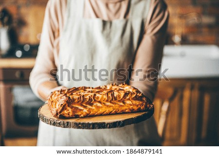 Senior woman holding sweet pie.