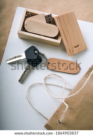   a wooden flash drive in a box lies on a wooden table. keys with a wooden natural keychain close-up. mockup top view                             
