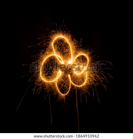 Abstract illustration in the form of a flower with sparklers on a black background