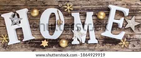 Home - white letters with gold christmas decoration on old wood