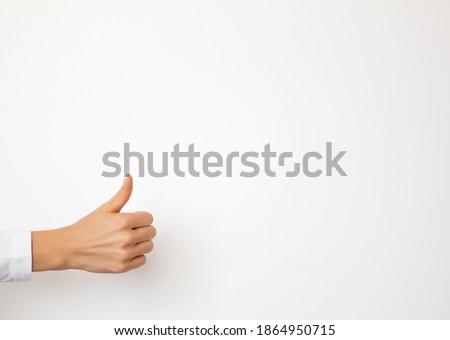 Person showing thumbs up gesture on clean white background