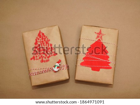 Two gift boxes packing in craft paper and bow rope on brown background. happy new year and merry christmas.