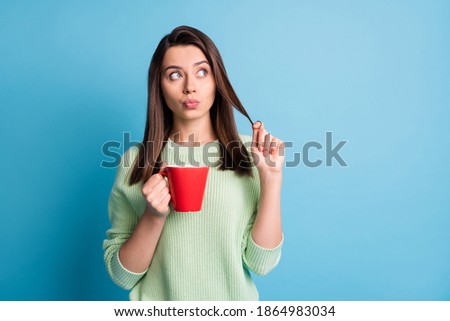 Photo of minded girl hold cacao cup look empty space think thoughts isolated over blue color background
