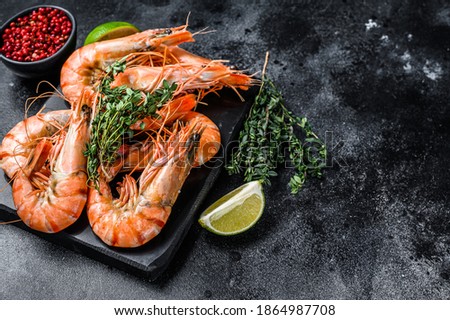 Red Langostino shrimps Prawns on a marble board.  Black background. Top view. Copy space. Royalty-Free Stock Photo #1864987708