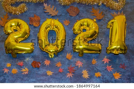 Gold numbers 2021 and next to them holiday items on a black or dark background. Christmas or New Year background.  autumn leaves. new year christmas

