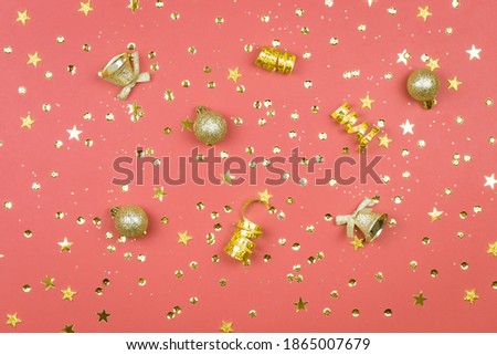 Coral background with glitter, golden stars and decorations. Sparkling texture. Festive backdrop for your projects.
