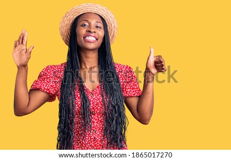 Young african american woman wearing summer hat showing and pointing up with fingers number six while smiling confident and happy. 
