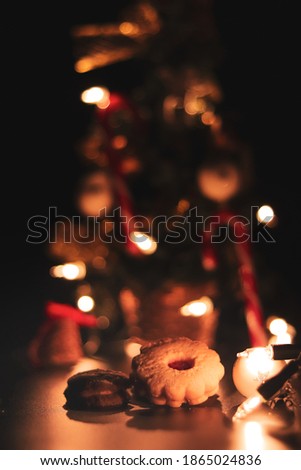 Christmas cookies together with a decorated Christmas tree with a pleasantly warm golden light. Linen cookies with rum balls. Dessert after dinner. Sweets with honey.