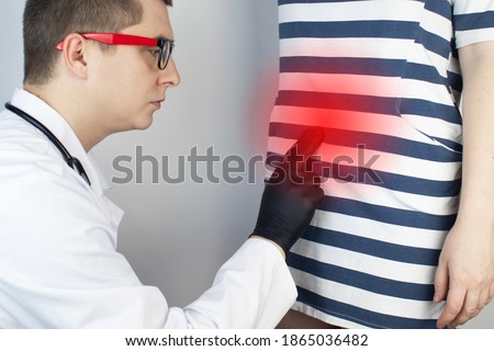 A woman suffers from pain in the appendix. Acute appendicitis, Crohn's disease, or inflammatory bowel disease. Surgeon examination and preparation for laparoscopic appendectomy Royalty-Free Stock Photo #1865036482