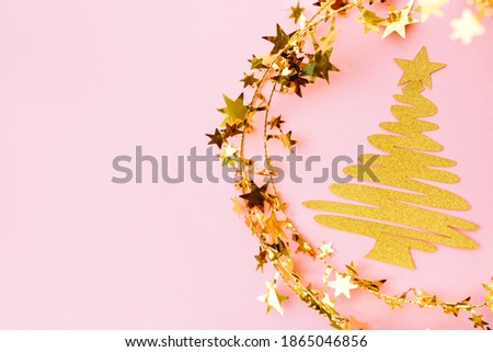 Golden and white glitter decoration and pink background. Celebration minimal Christmas tree.