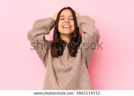 Young mixed race hispanic woman isolated laughs joyfully keeping hands on head. Happiness concept.