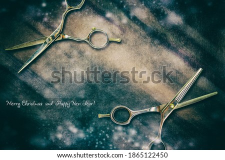 Barber scissors on a dark blue grunge background. Snow effect.Copy space. New Year's greetings from the hairdresser. Festive background.