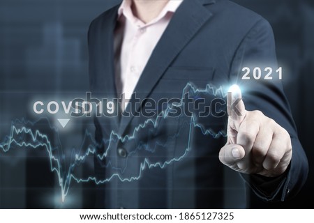 concept of economic recovery after the fall due to the covid 19 coronavirus pandemic. Double exposure of financial graph. Businessman pointing graph corporate future growth plan on dark blue Royalty-Free Stock Photo #1865127325