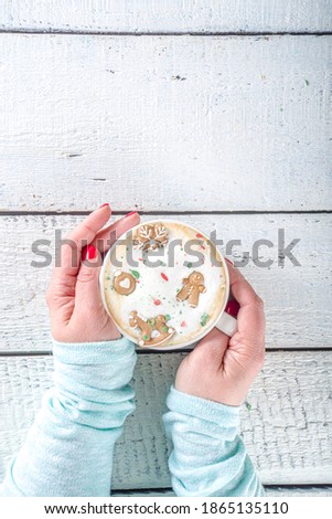 Coffee Latte or Hot Chocolate Mug with Funny Little Marshmallows in Gingerbread Cookie Forms - Gingerbread man, Snowflake, Christmas Tree Toys Cute and Cozy Winter Drink Background, cup in Woman Hands