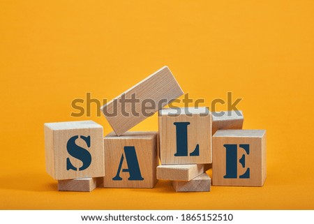 wooden blocks with the wordings SALE, isolated against yellow background.